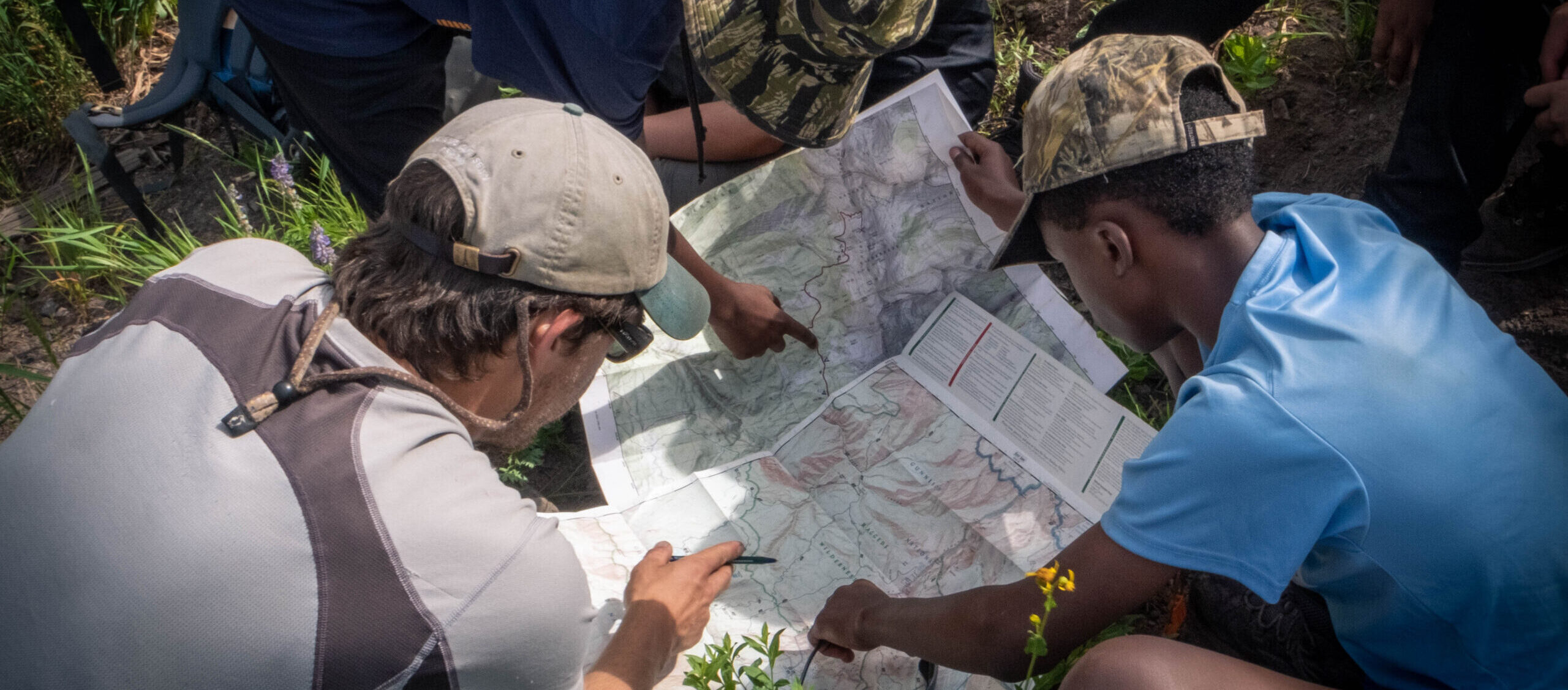 Two kids and mentor reviewing maps